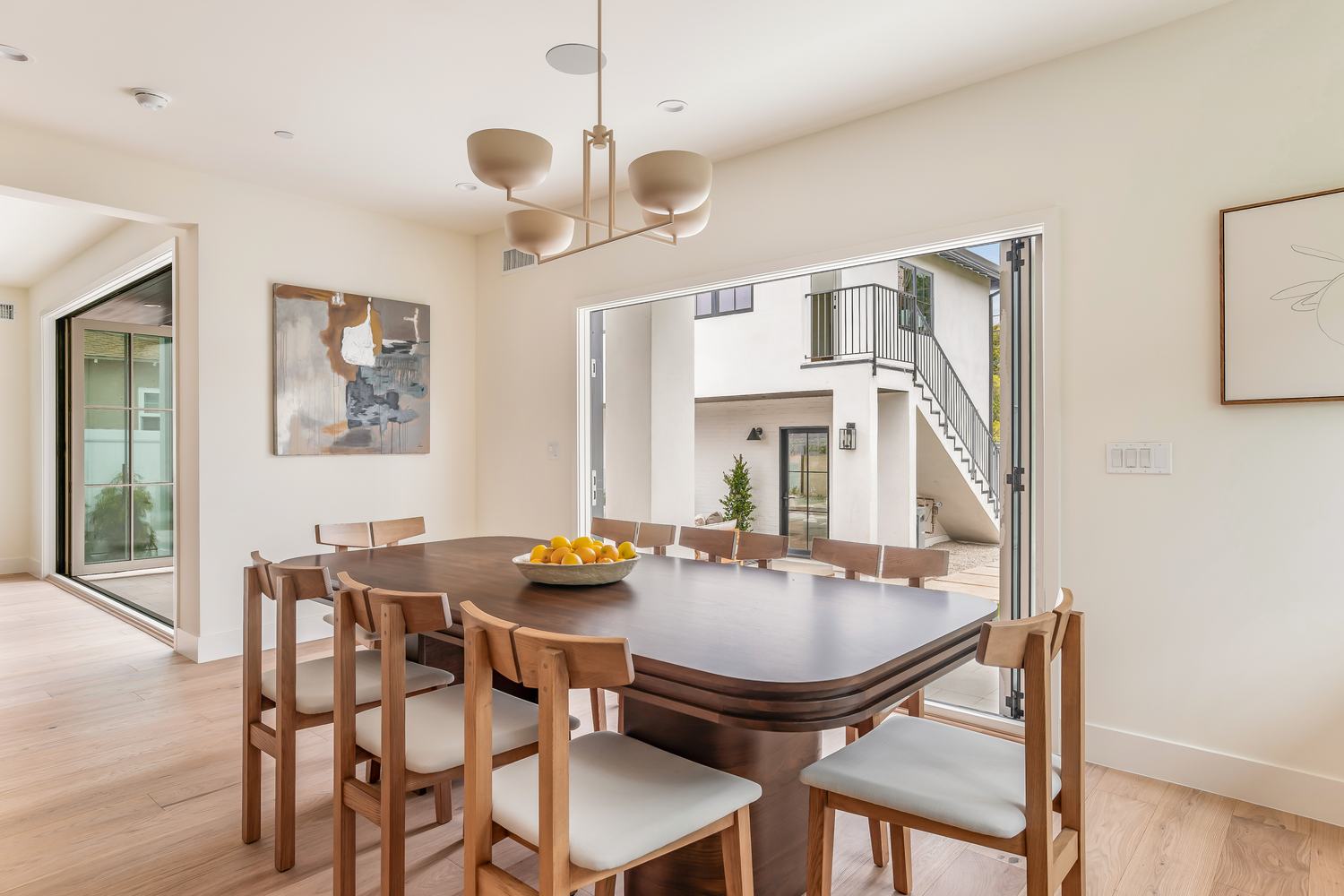 Dining room opening onto a courtyard, staircase visible beyond