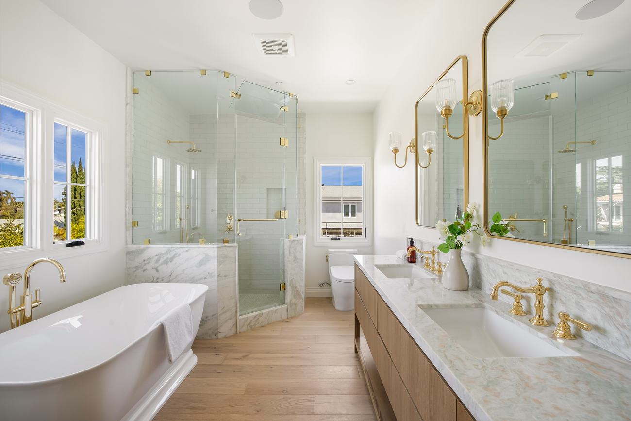 Primary bath with freestanding tub, glass shower, and brass fixtures