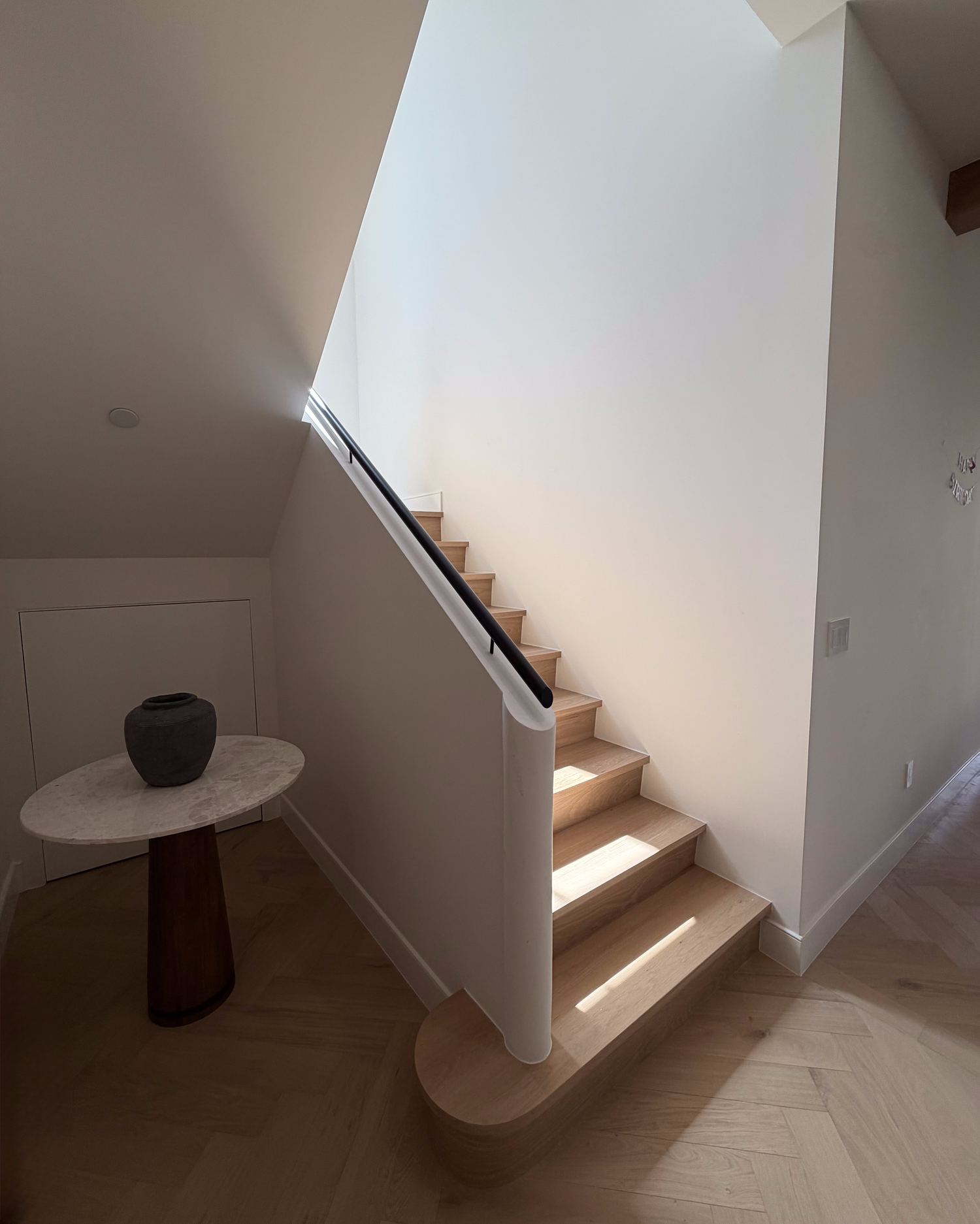 Staircase with white oak treads and herringbone wood flooring
